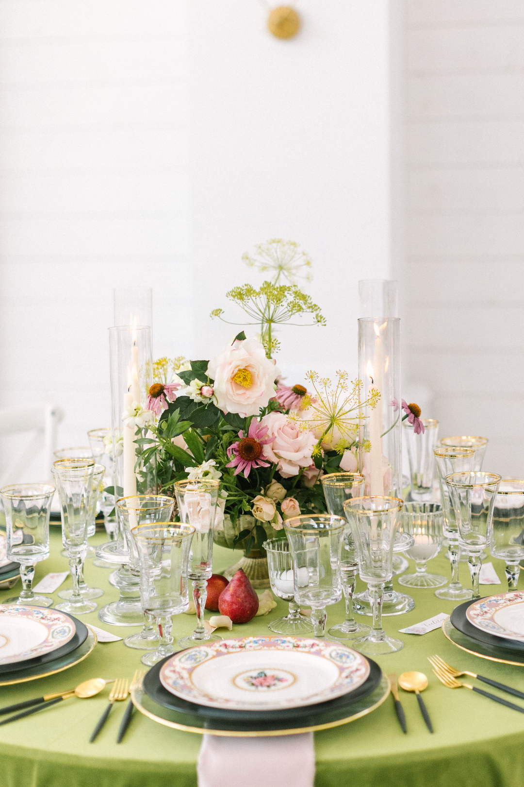 event table with gold table settings and multicolor floral centerpiece